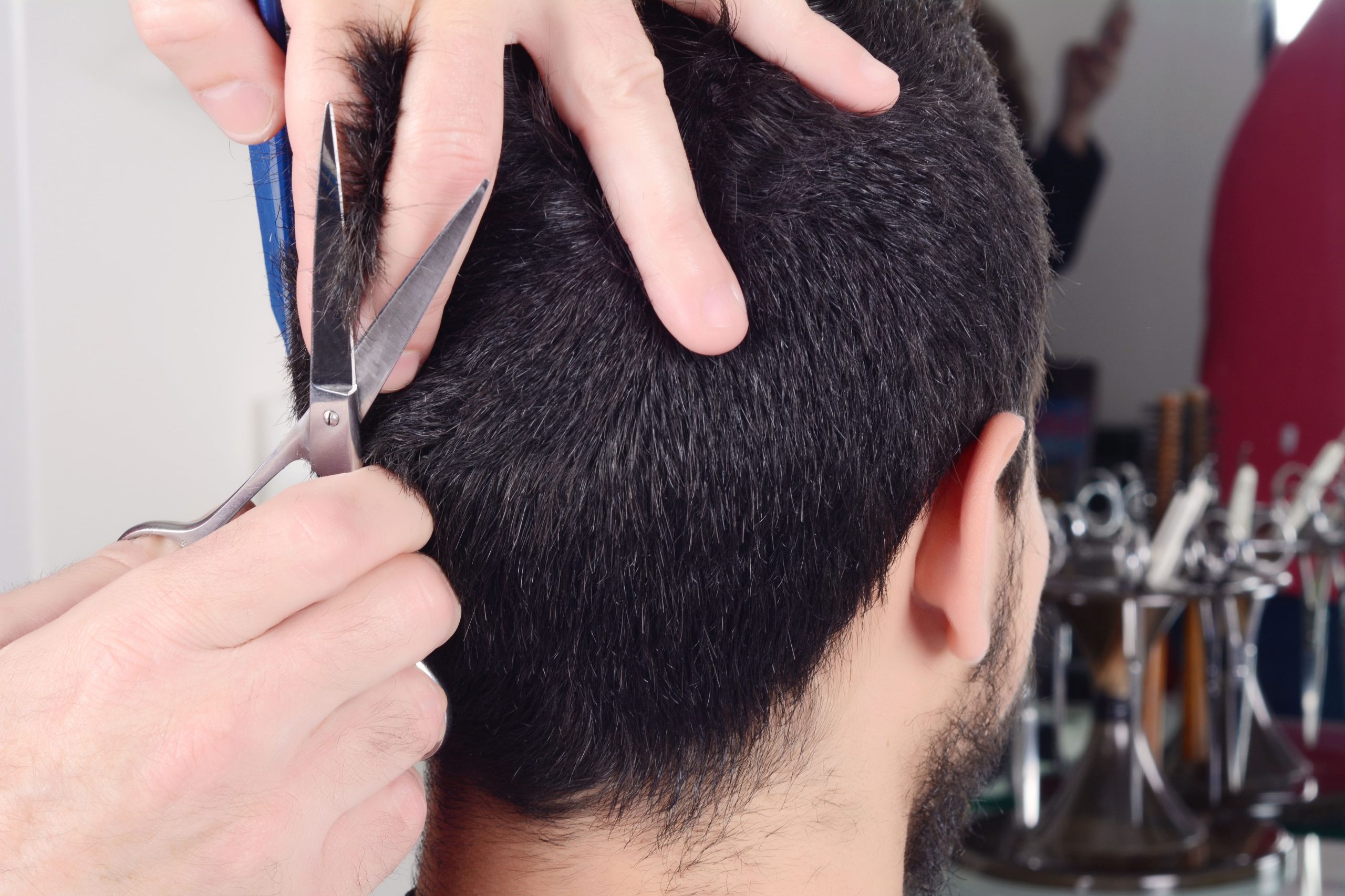 Barbero realizando corte de pelo con tijeras a caballero en Robles Peluqueros